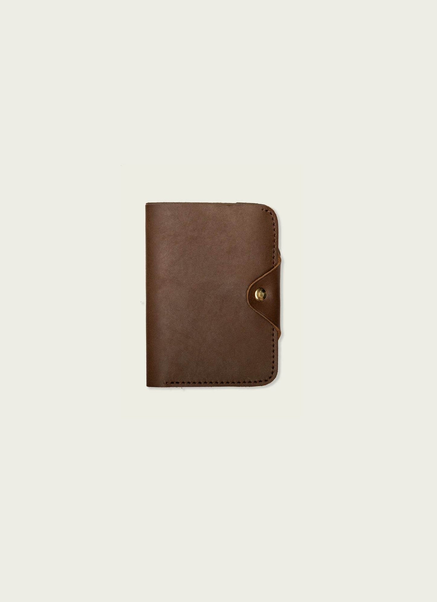 Men's chocolate brown leather passport wallet with snap closure on plain background