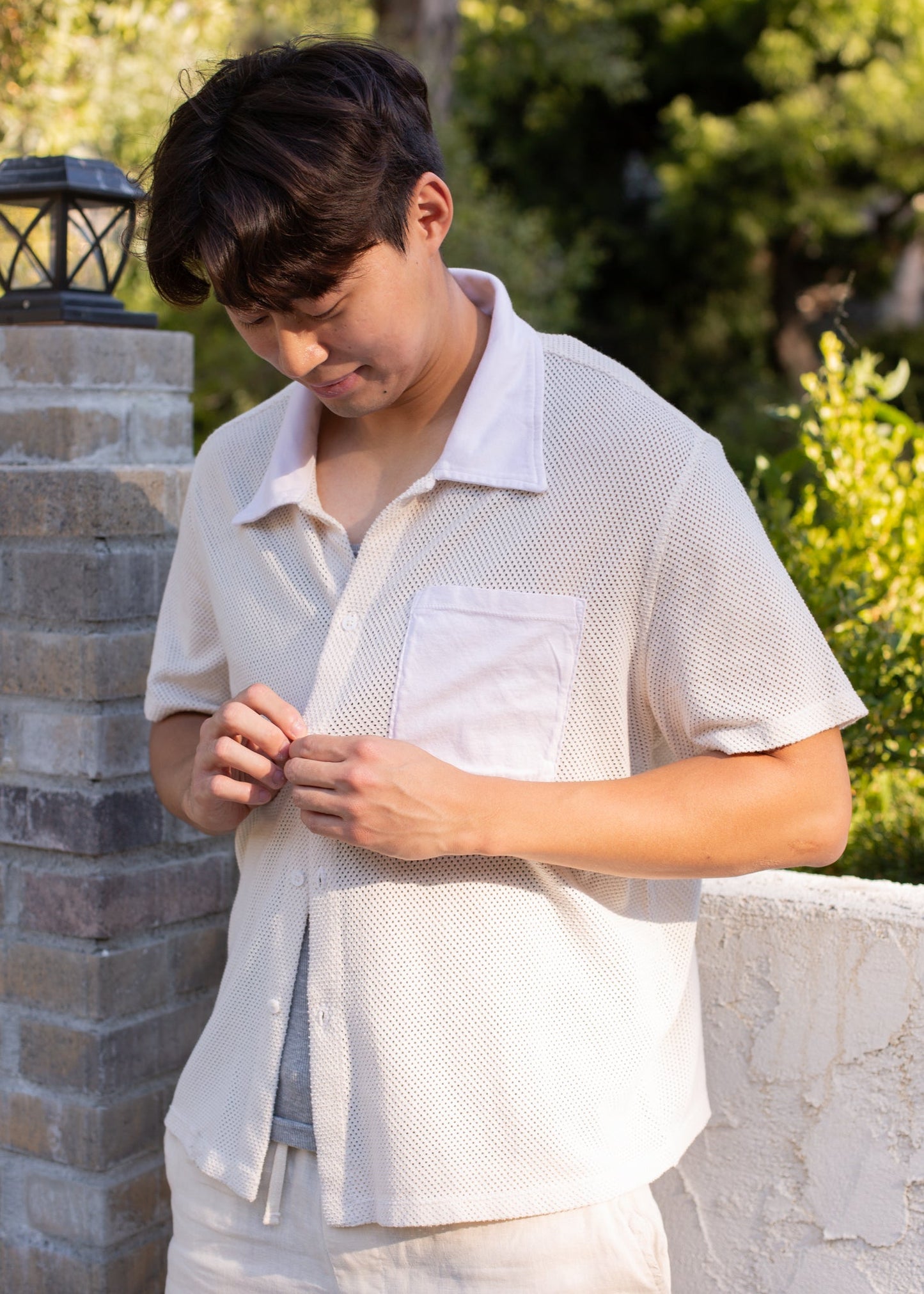 Man wearing a coconut milk mesh button-down shirt outdoors, stylish men’s summer fashion