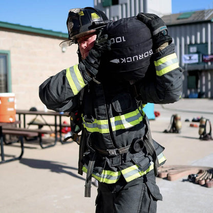 Firefighter training outdoors, carrying heavy ruck sack, safety gear, Mann men's lifestyle