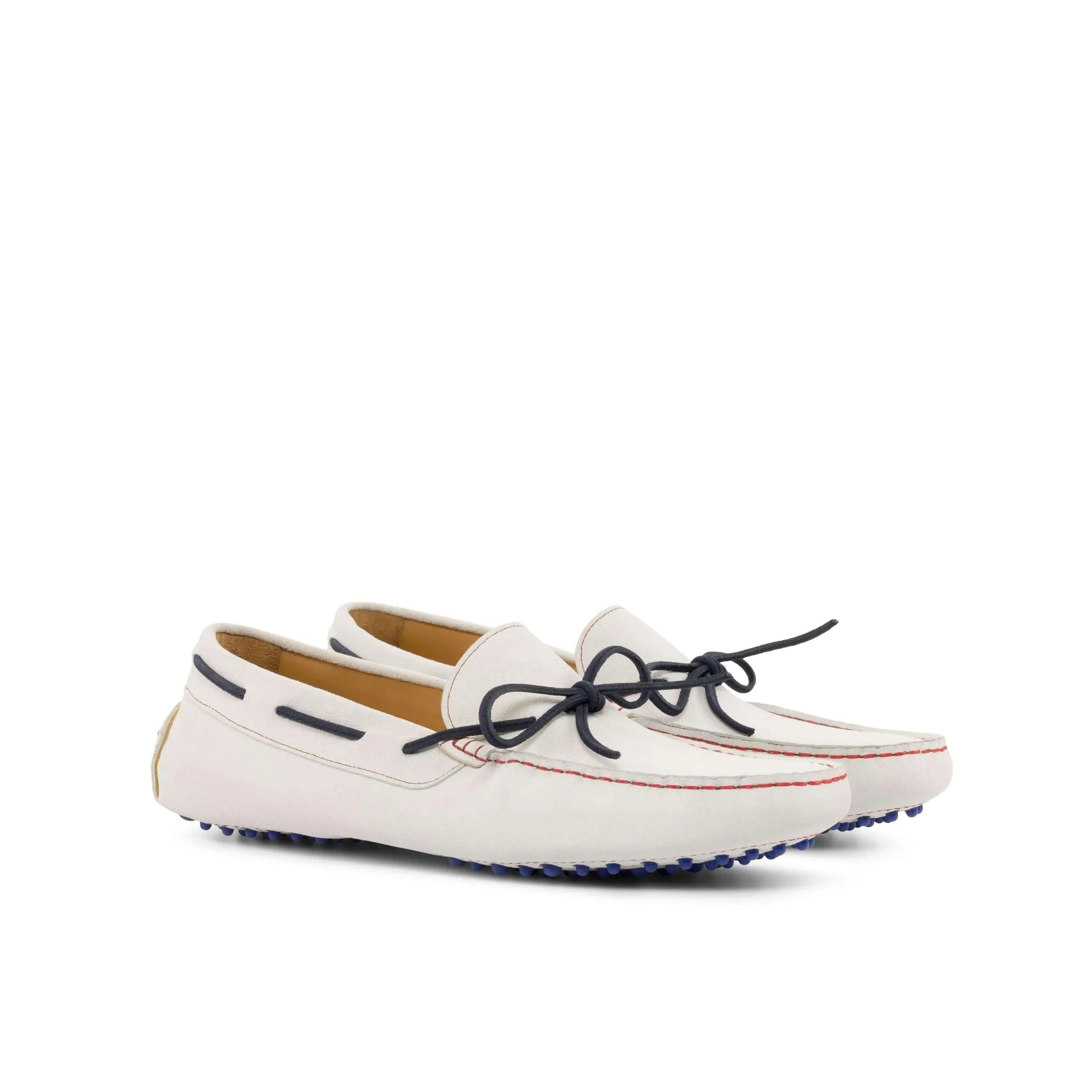 White leather driving shoes with navy laces, featuring rubber soles for comfort