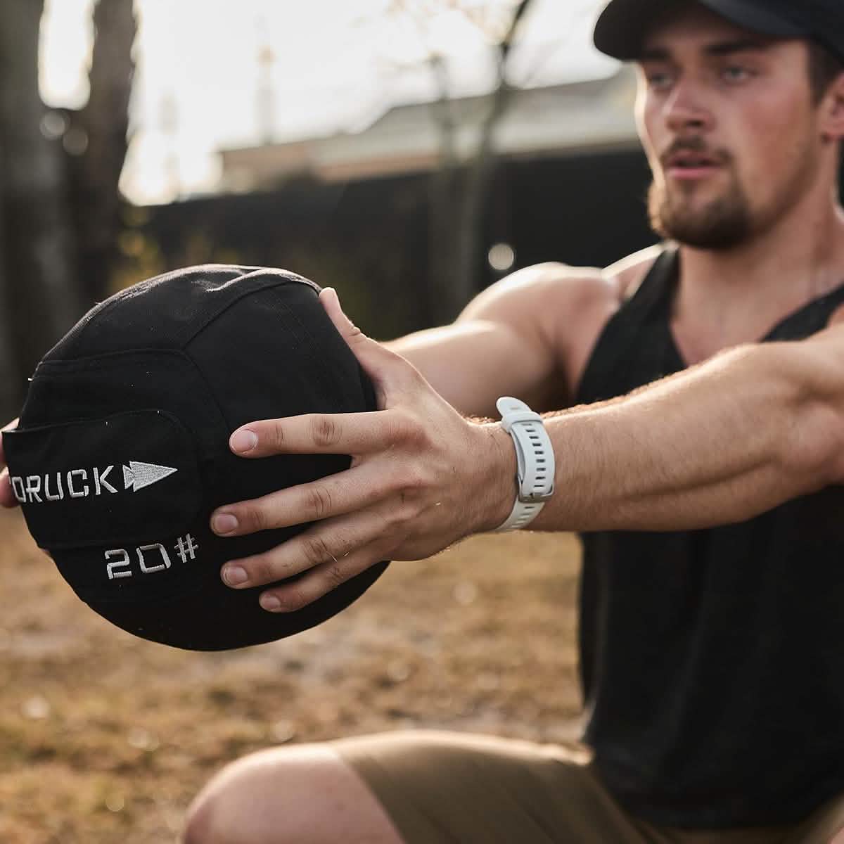 Man exercising outdoors with a GORUCK 20 lb medicine ball, fitness lifestyle for men
