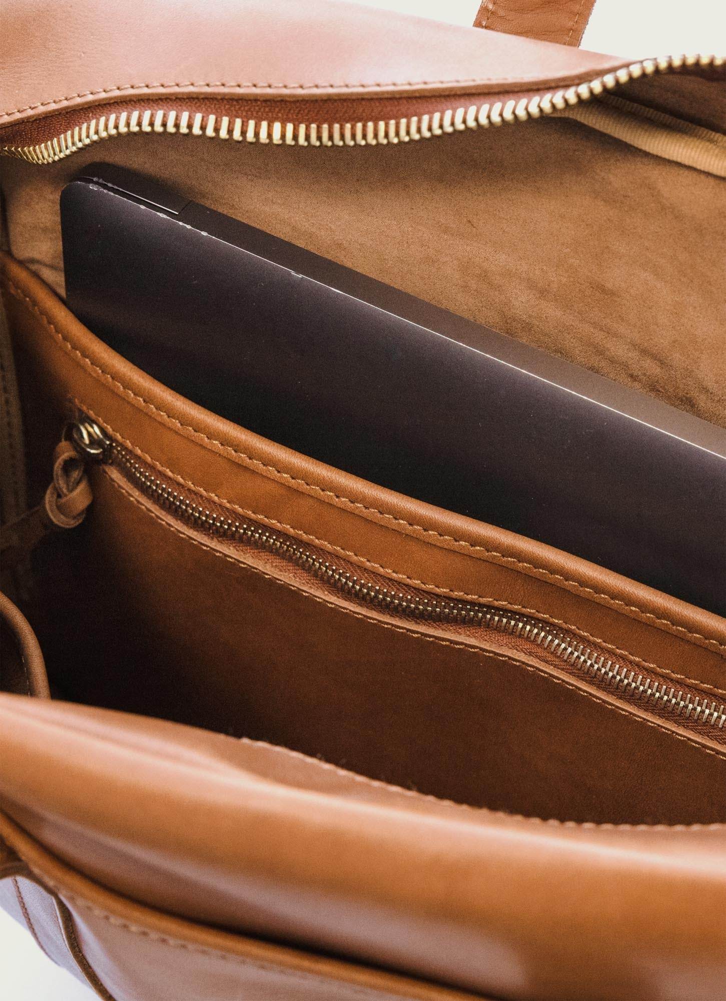 Interior of a tan leather men's laptop bag with zip pocket, featured on MANN marketplace.