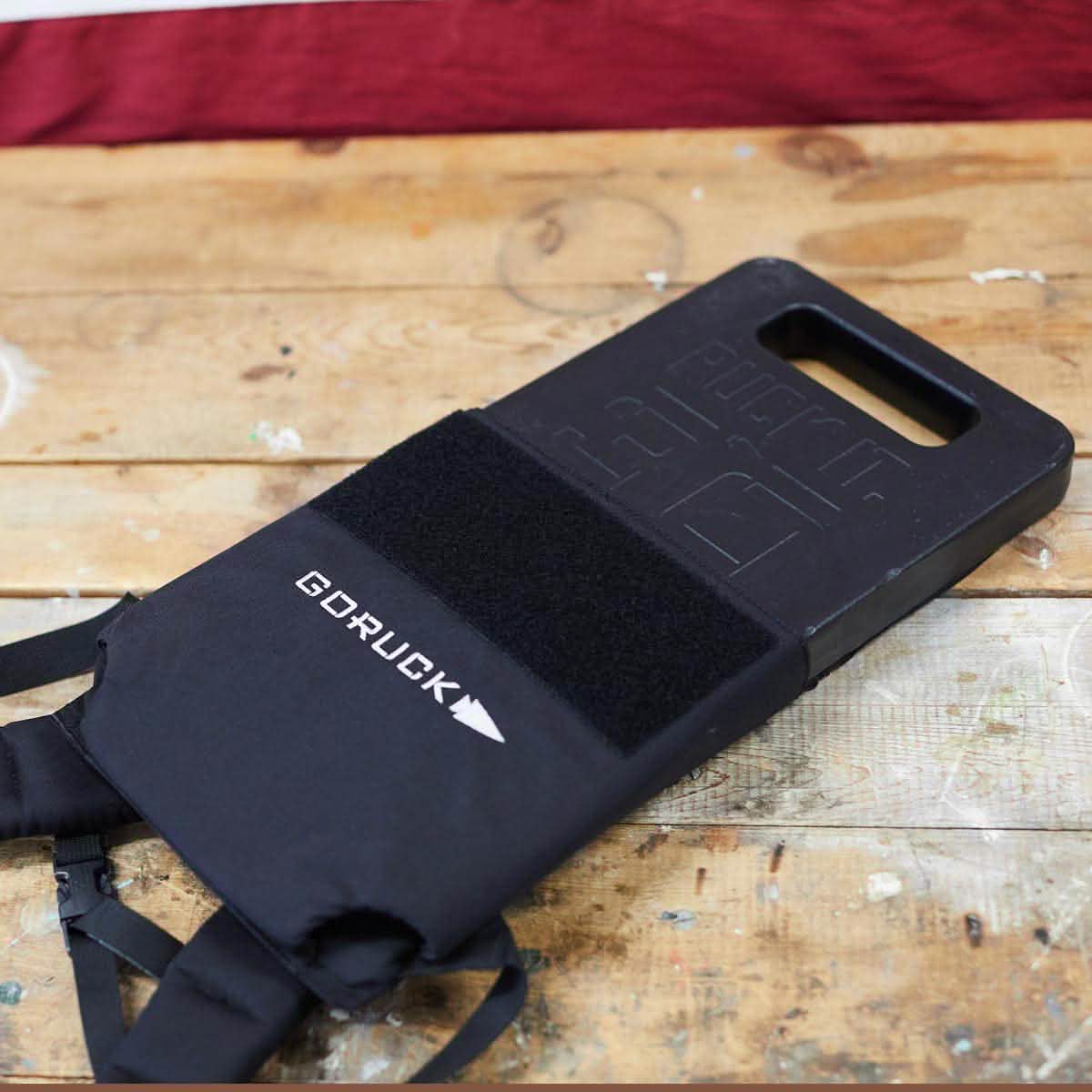 GORUCK 30lb ruck plate for men, black weight plate on rustic wood table, MANN lifestyle gear