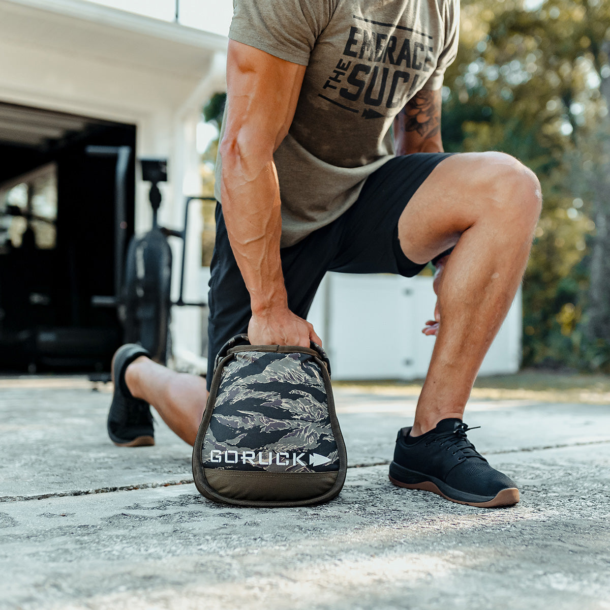 Man in athletic wear doing outdoor workout with GORUCK sandbag, fitness and lifestyle gear