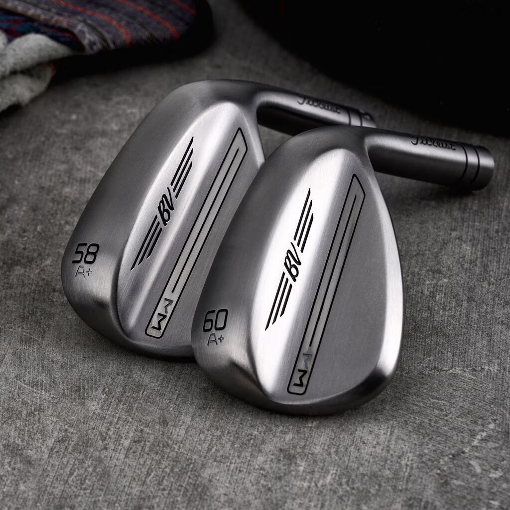Two sleek Titleist BV golf wedges on a grey surface, showcasing 58 and 60 degree clubs.