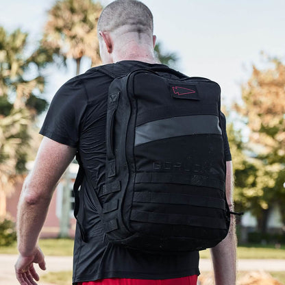 Man wearing black tactical backpack outdoors, men's lifestyle, curated gear by MANN