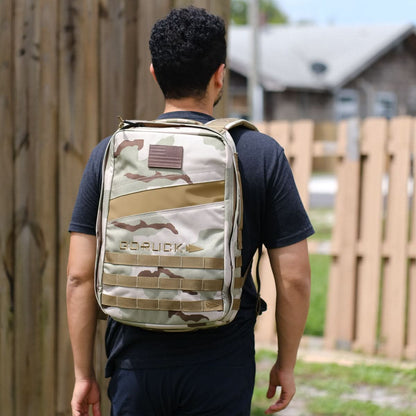 Man outdoors wearing GORUCK camo backpack, casual black t-shirt, curated men's gear