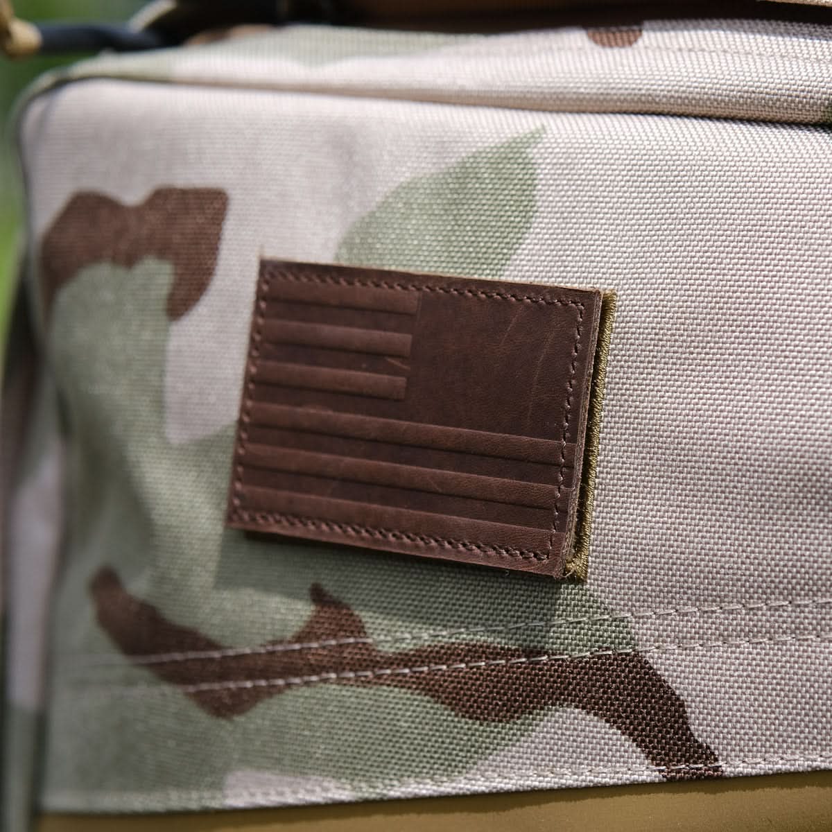 Camo backpack with brown leather American flag patch, men’s lifestyle accessory