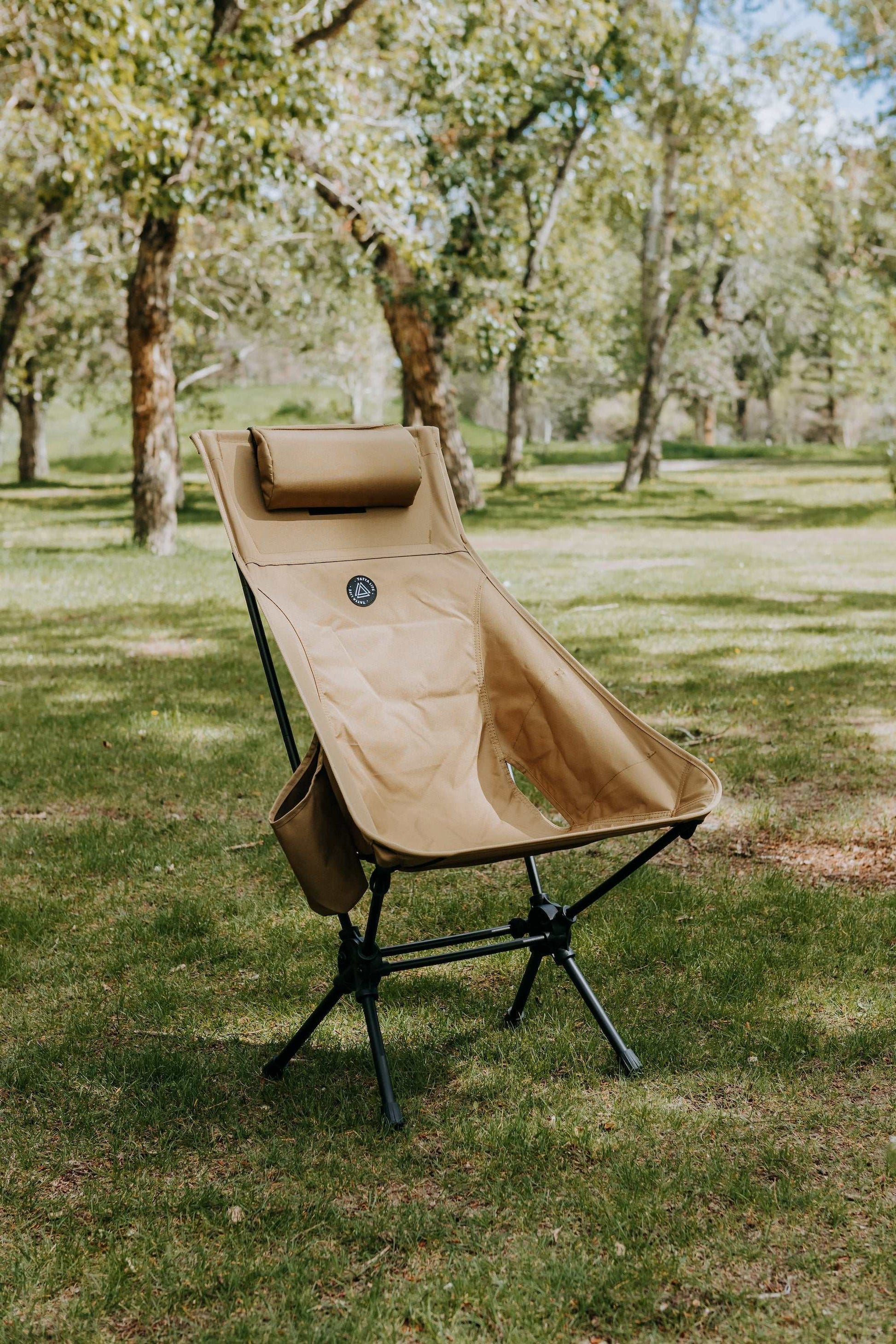 High back ultralight folding camping chair with storage pouch in outdoor setting.