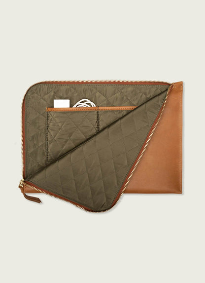 Tan leather laptop case with quilted olive interior, zipper closure, and inner pockets for accessories.