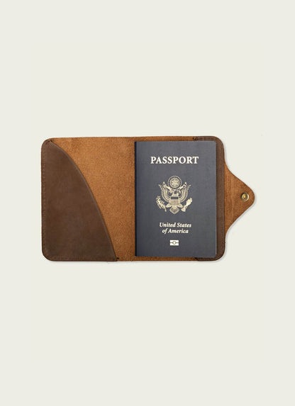 Brown leather passport wallet holding a US passport on a light background, men's travel accessory