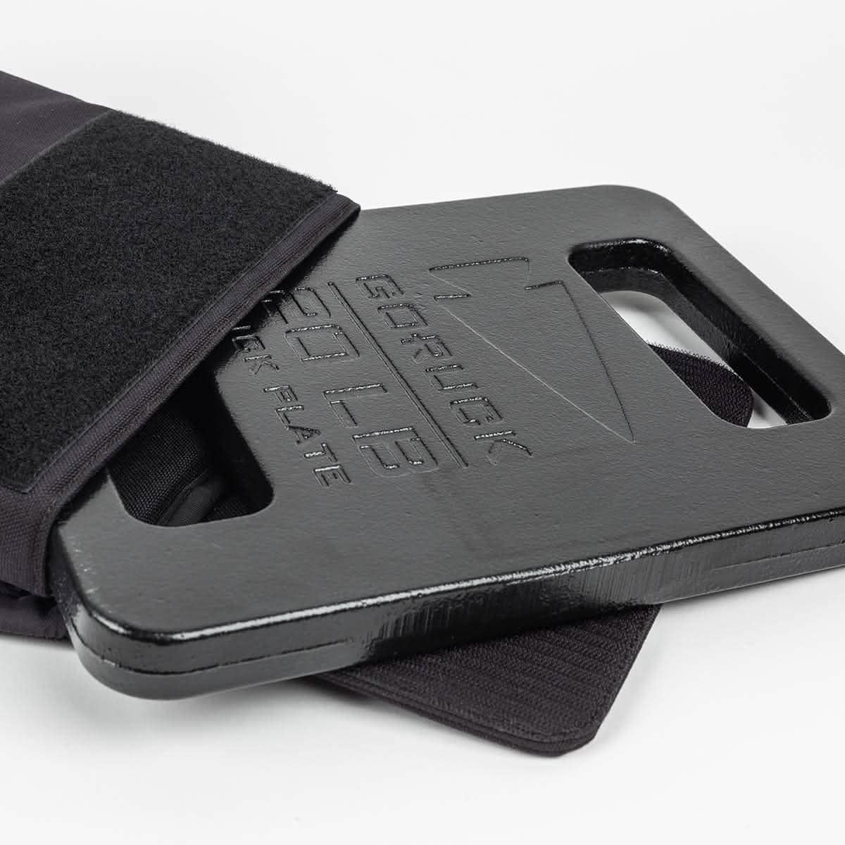 GORUCK 20LB black ruck plate partially inside a tactical backpack, men's fitness gear