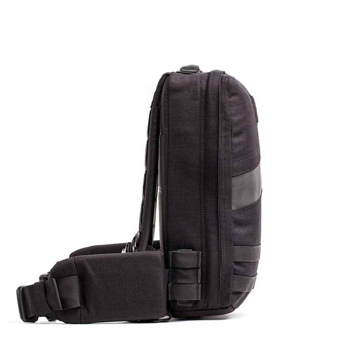 Side view of black and orange 15L men's rucksack with padded hip belt, featured on MANN.