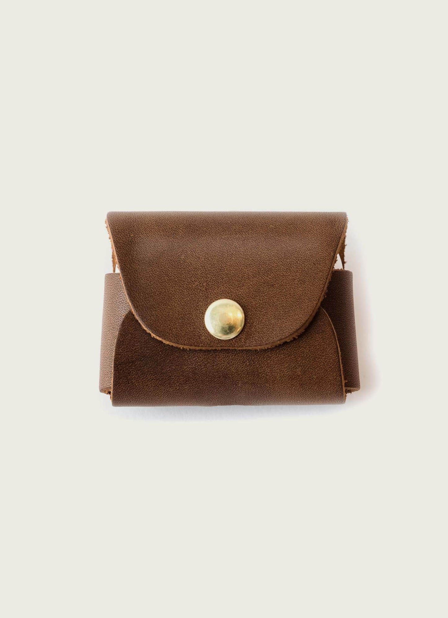 Brown leather wallet with brass snap button on white background, men's fashion accessory