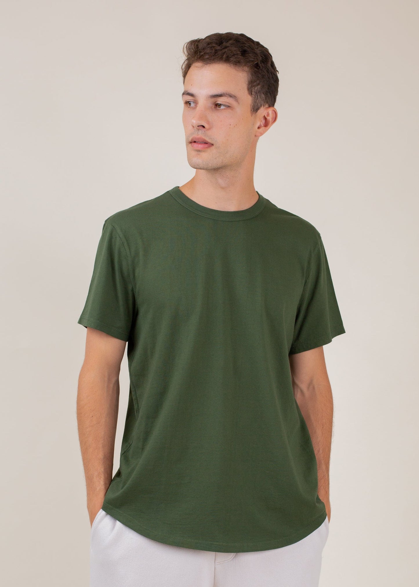 Man wearing classic forest green tee for men, minimalist style, neutral background