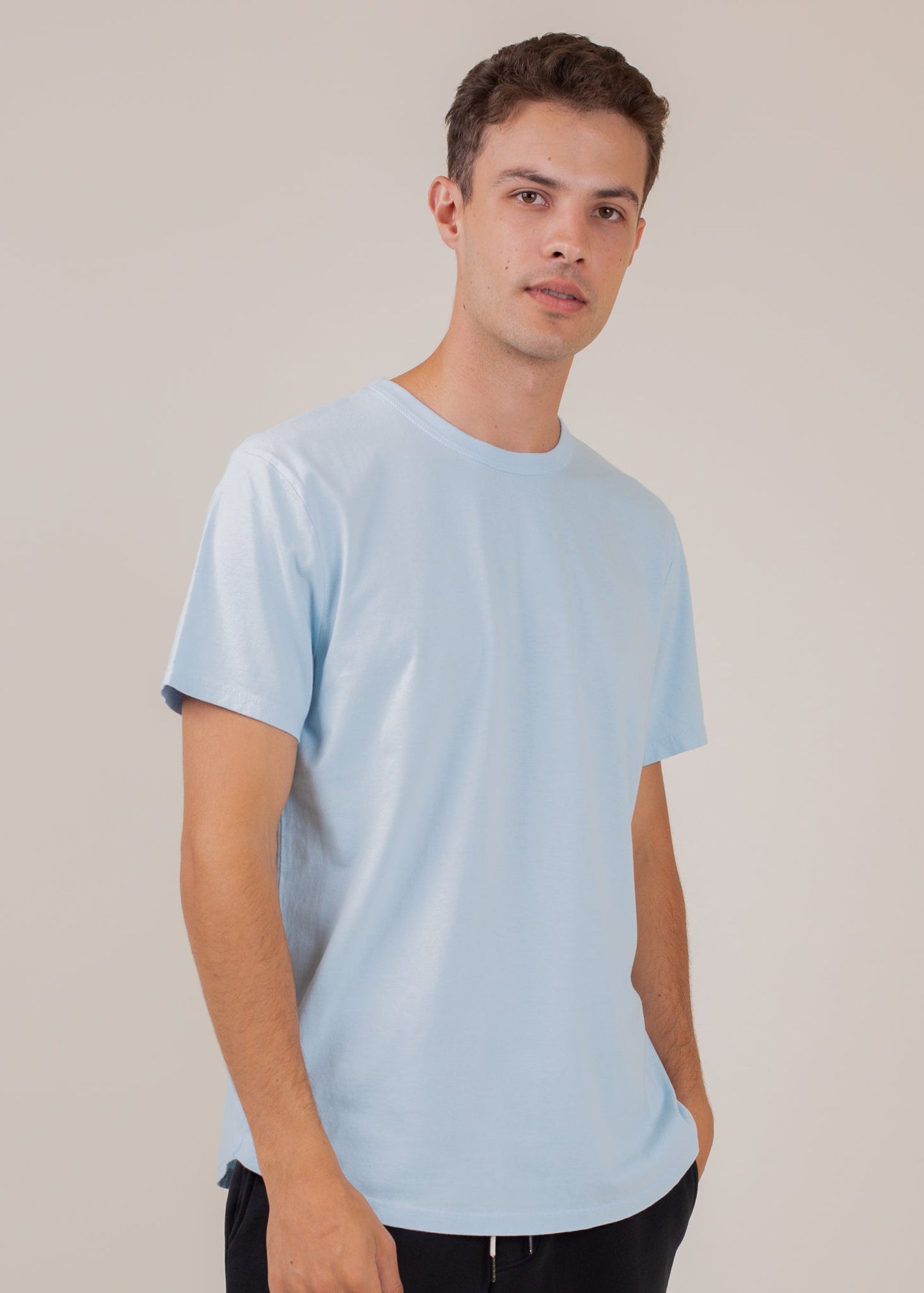 Man wearing a classic light blue tee from MANN, men's fashion, neutral background
