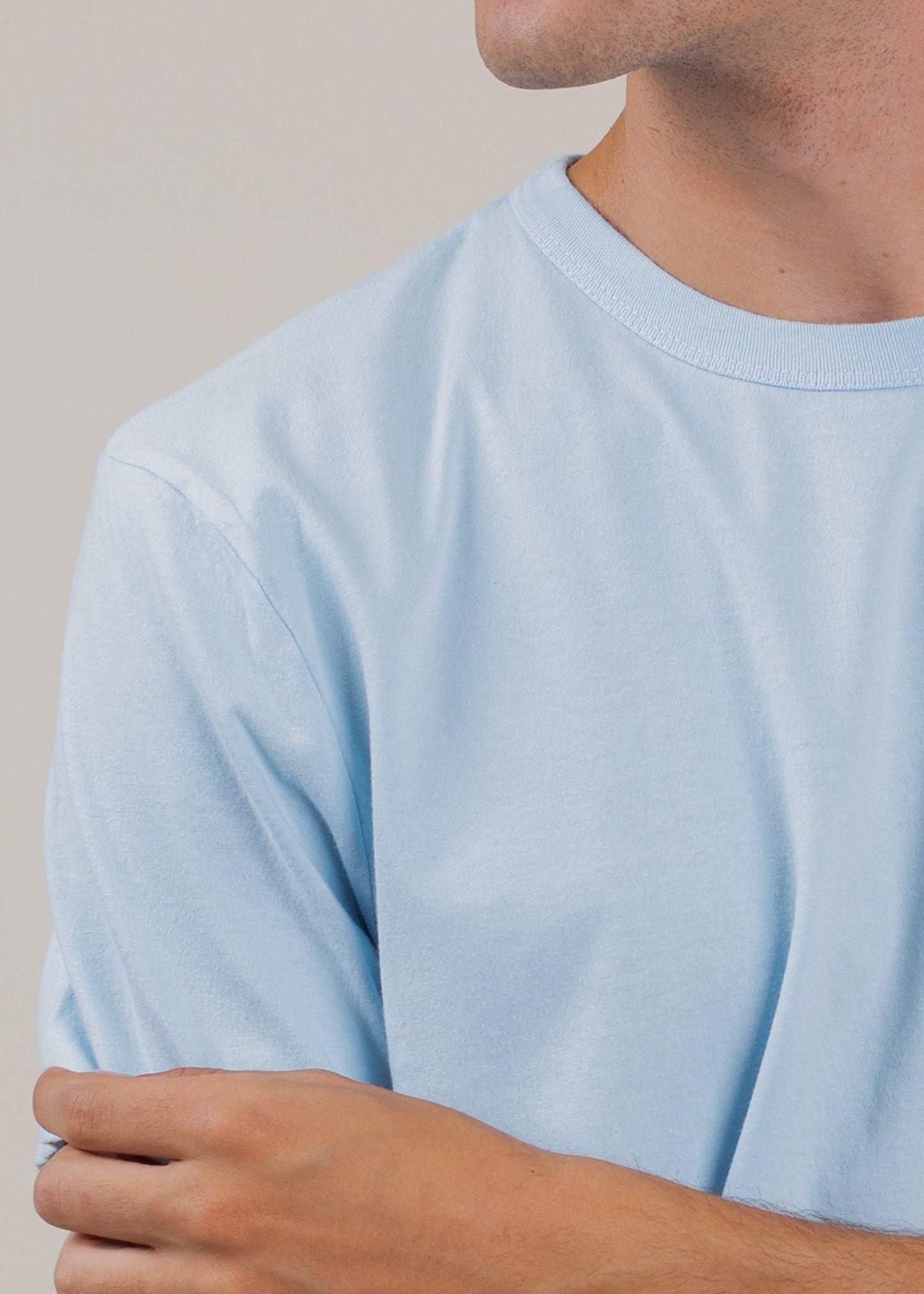 Close-up of a man wearing a light blue classic tee, minimalist men's fashion by MANN