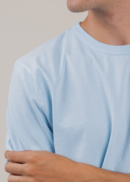 Close-up of a man wearing a light blue classic tee, minimalist men's fashion by MANN