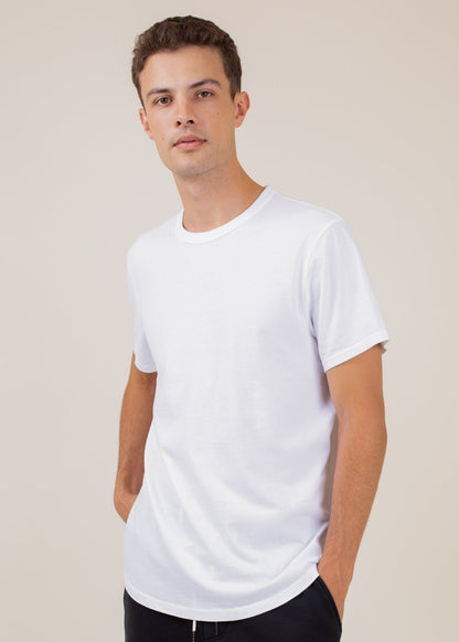 Man modeling classic white t-shirt against plain background for MANN men's fashion
