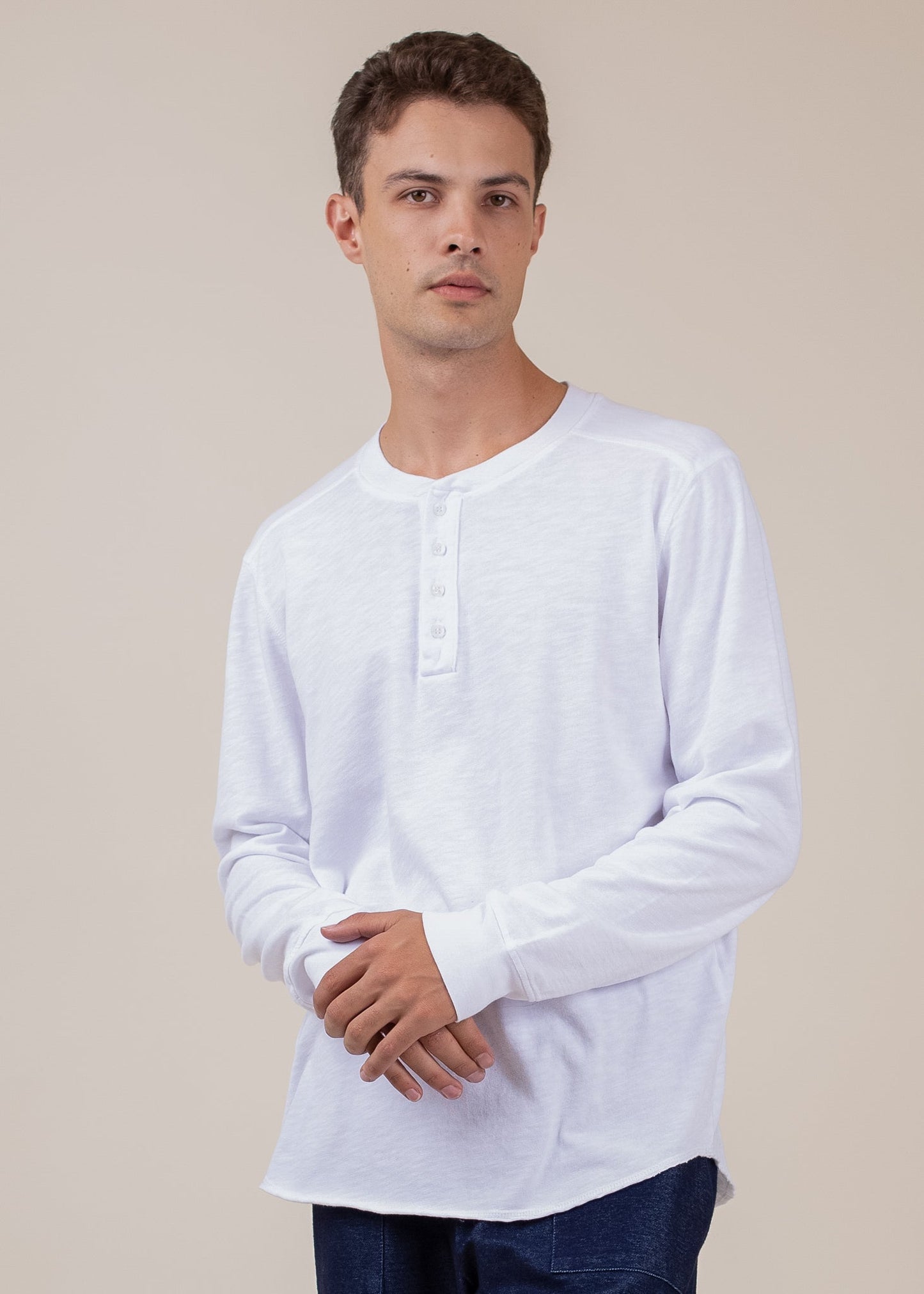 Man modeling a white long sleeve Henley shirt from MANN men's fashion