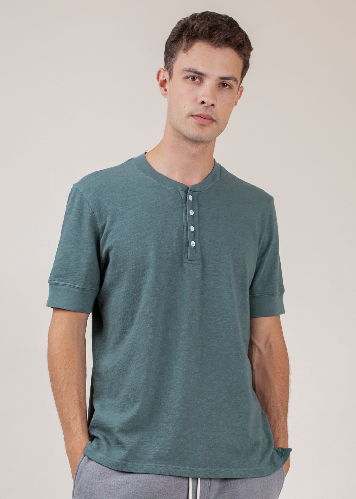 Man wearing a pine green short-sleeve henley t-shirt, casual menswear from MANN