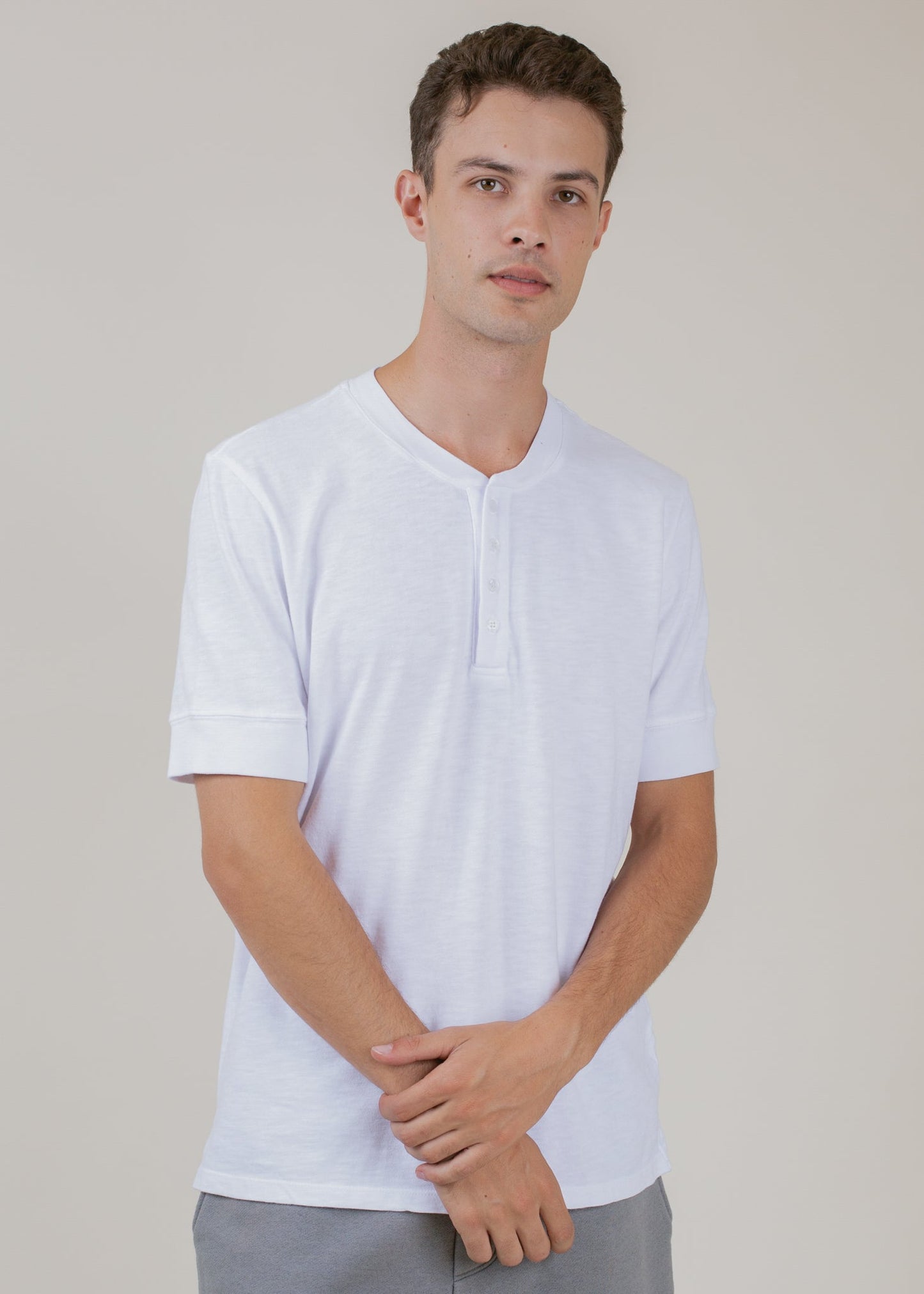 Man wearing a white Henley tee, modern men's fashion, MANN marketplace style
