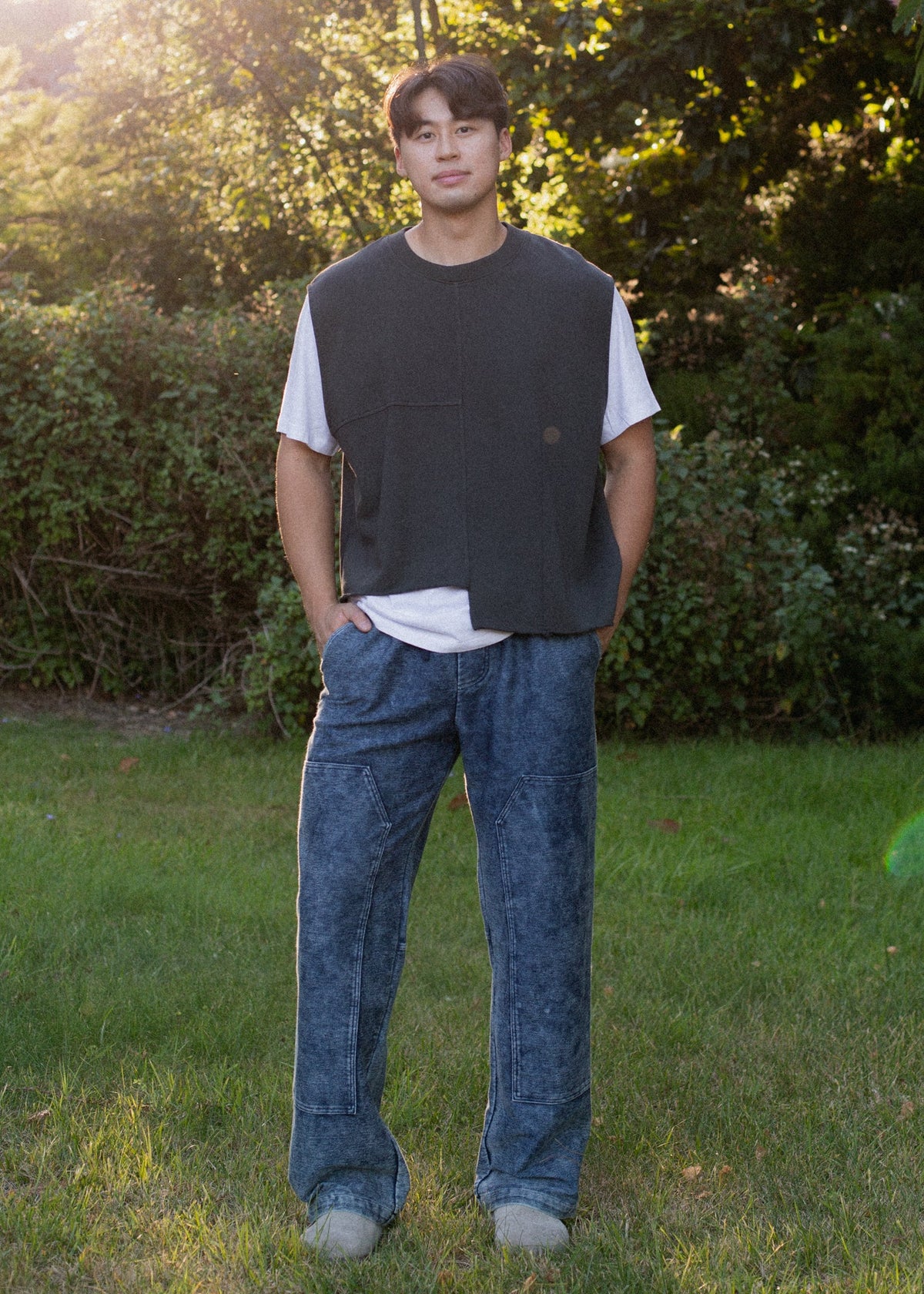 Man wearing indigo patch trousers and casual vest outdoors, men's fashion from MANN marketplace