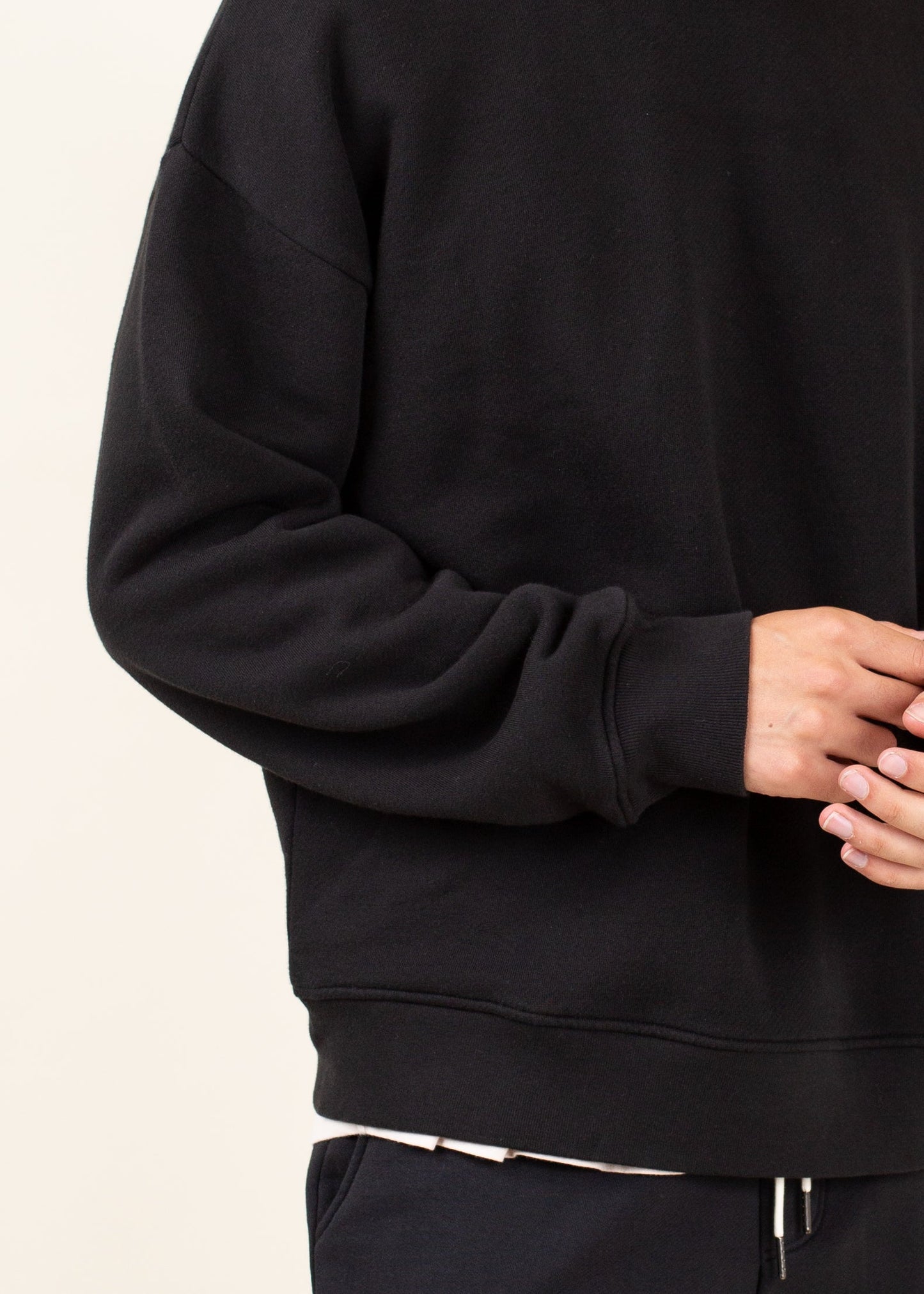 Man wearing black crewneck sweatshirt and joggers, minimalist men's fashion
