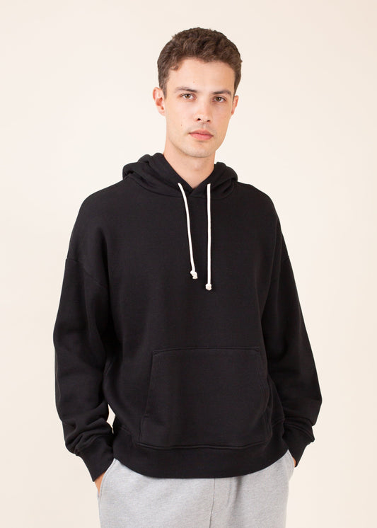 Man wearing black hoodie and gray sweatpants, minimalist men's casual fashion from MANN marketplace