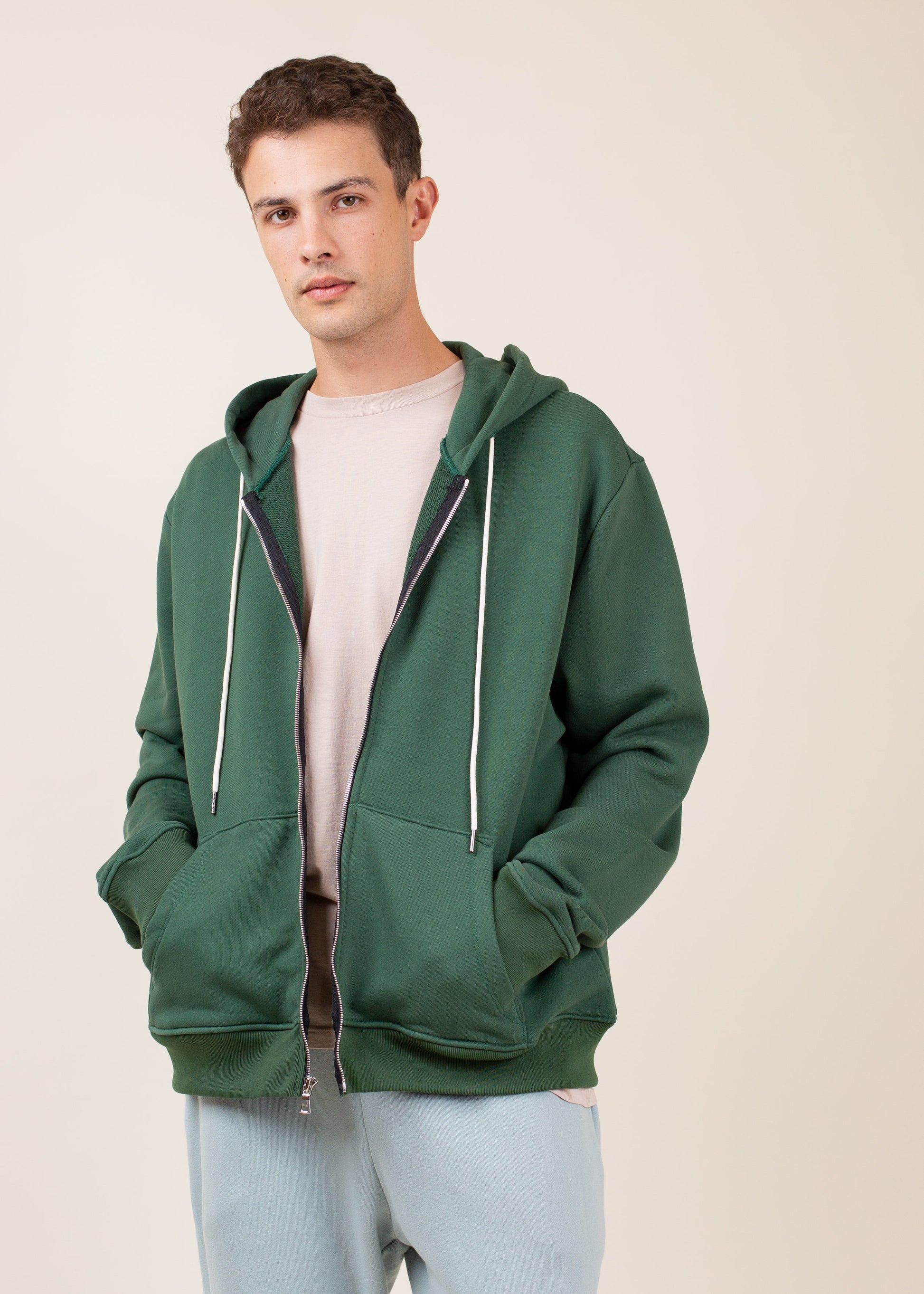 Man wearing green zip-up hoodie and light shirt, casual men's fashion for Mann lifestyle store