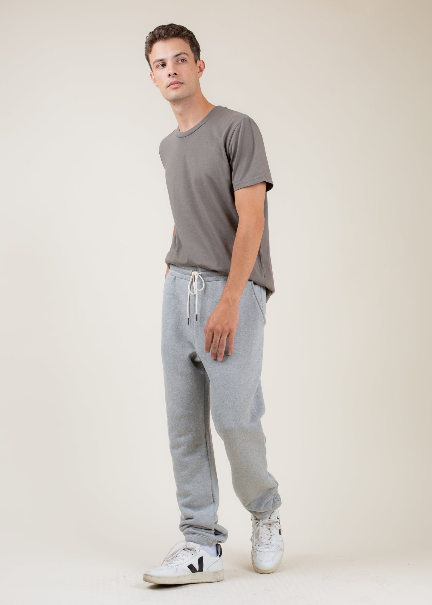 Man in gray t-shirt and light gray joggers with white sneakers, casual men's fashion