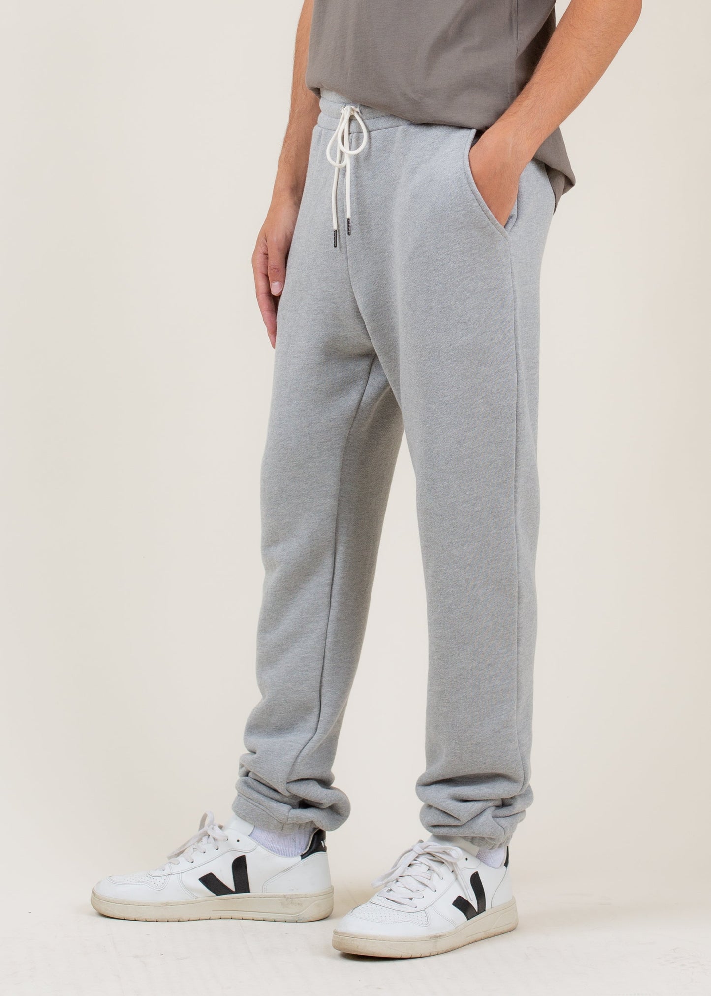Men's light grey sweatpants with drawstring and white Veja sneakers, casual style