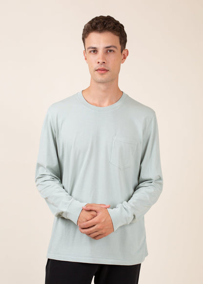 Man wearing light sage green long-sleeve shirt with chest pocket, neutral background