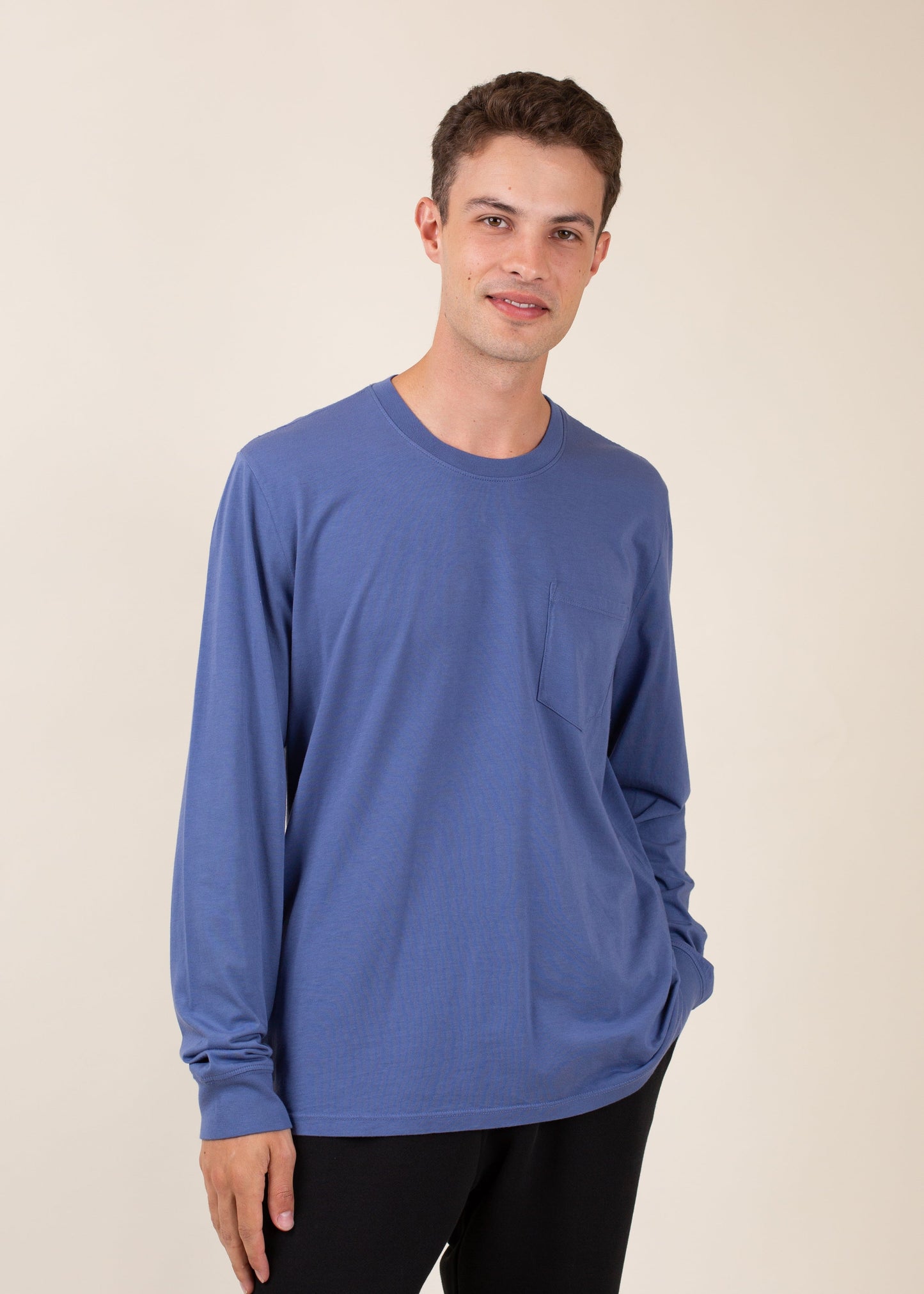 Man in blue long-sleeve shirt with chest pocket, casual fashion for men, neutral background