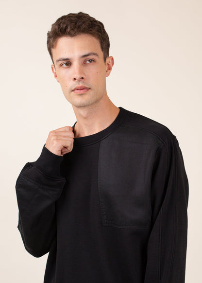 Man posing in black crewneck sweater against neutral background, men's fashion at MANN