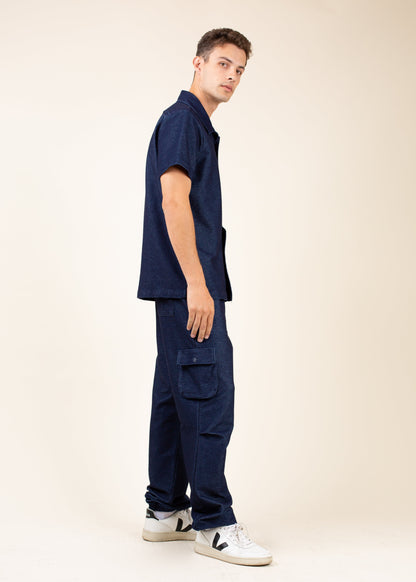Man in navy short-sleeve shirt and cargo pants, standing sideways, MANN men's fashion