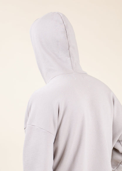 Back view of a light grey men’s hoodie against a beige background, fashion apparel from Mann marketplace