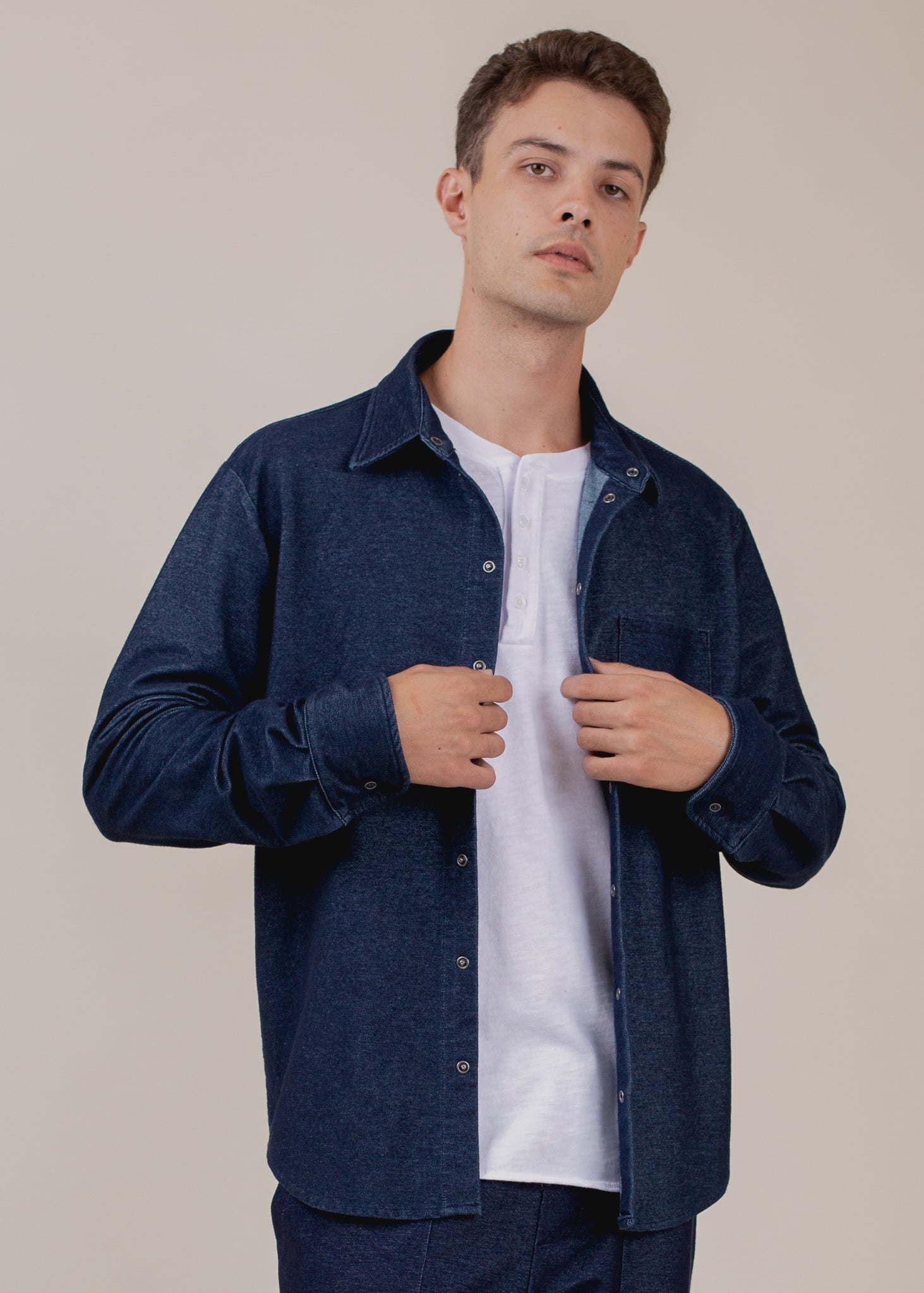 Man modeling navy indigo button-down shirt over white T-shirt, stylish men's fashion