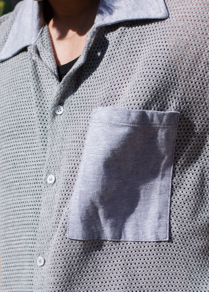 Close-up of a men's grey mesh button-down shirt with chest pocket, sunlight detail, MANN fashion