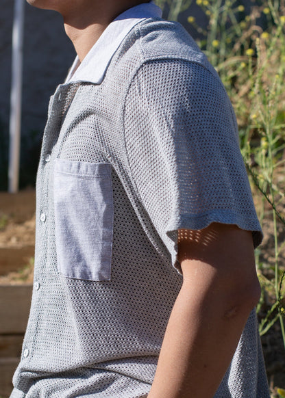 Man wearing a light grey mesh button-down shirt with chest pocket outdoors