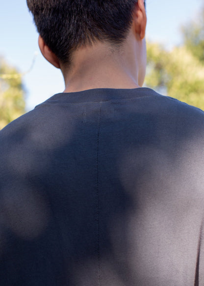 Back view of man wearing charcoal muscle tank outdoors, curated men's fashion on MANN