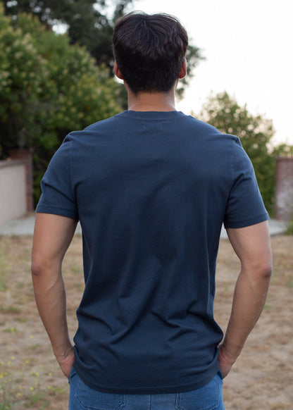 Man wearing organic navy basic tee outdoors, back view, men's fashion at MANN marketplace