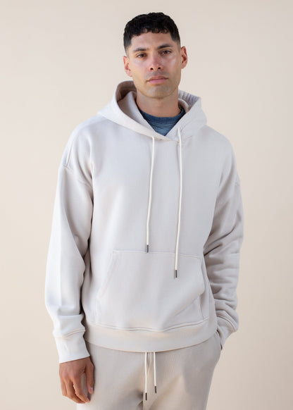 Man wearing cream hoodie and joggers, modern men's fashion, neutral background