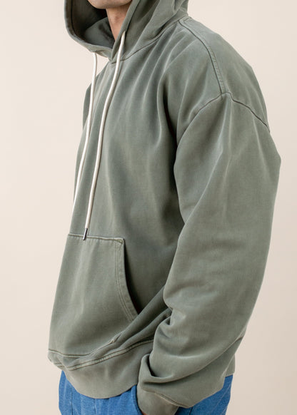 Man in an olive green hoodie with drawstrings and kangaroo pocket, casual men's fashion