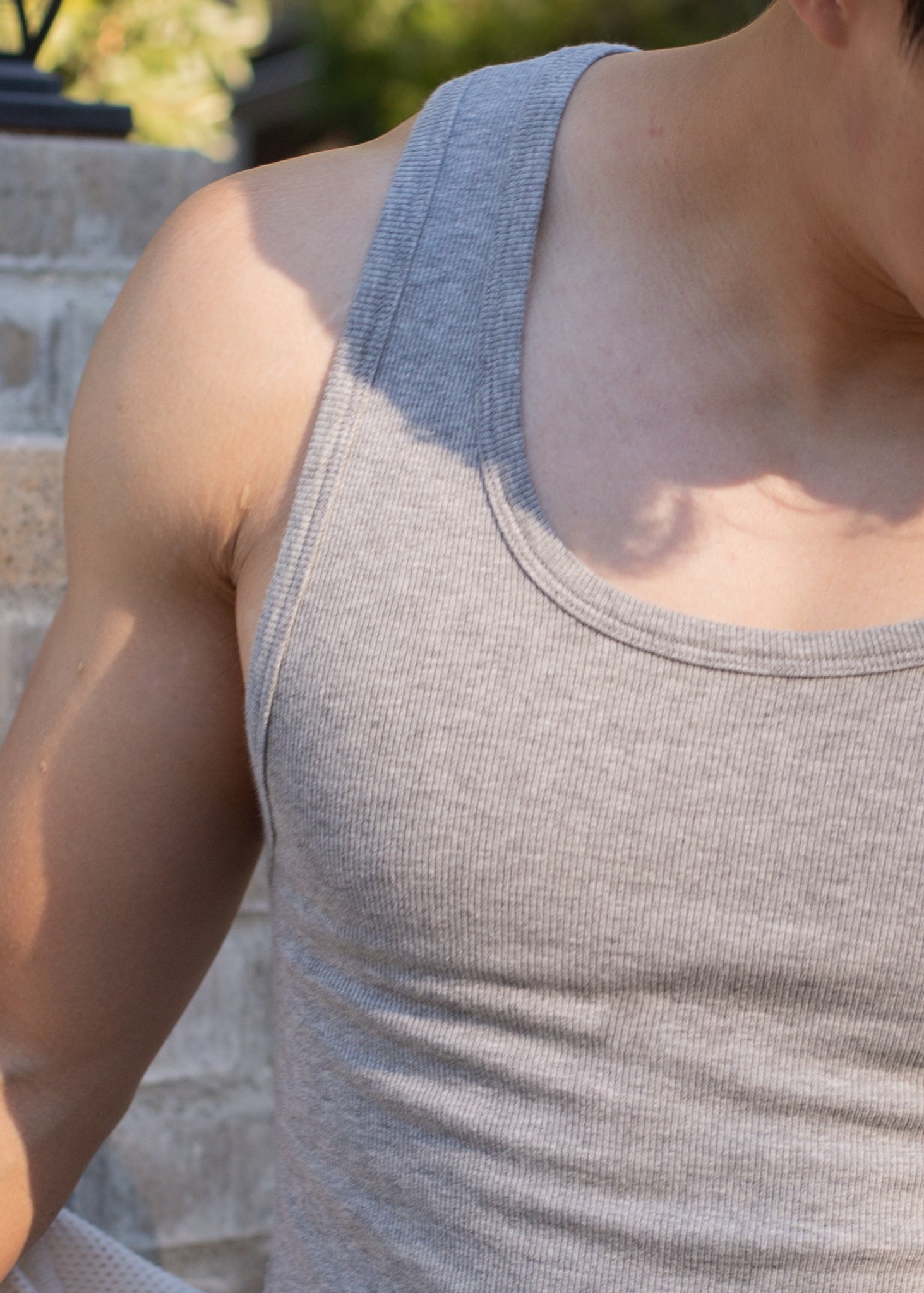 Close-up of man wearing grey ribbed tank top outdoors, casual men's fashion at MANN