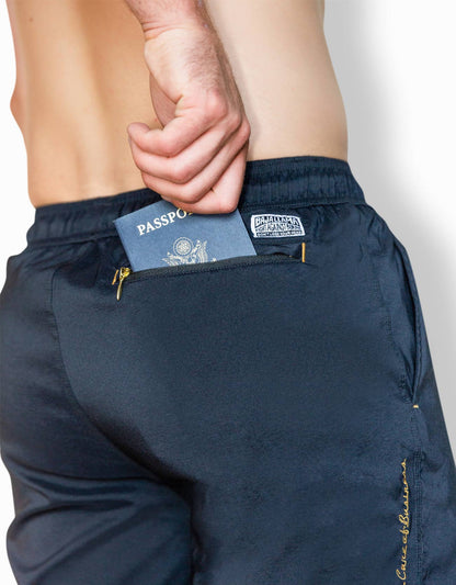 Men's black swimsuit. 6 inch stretch volley trunks. Gold finishes. Functional zipper pockets with internal stash pocket.